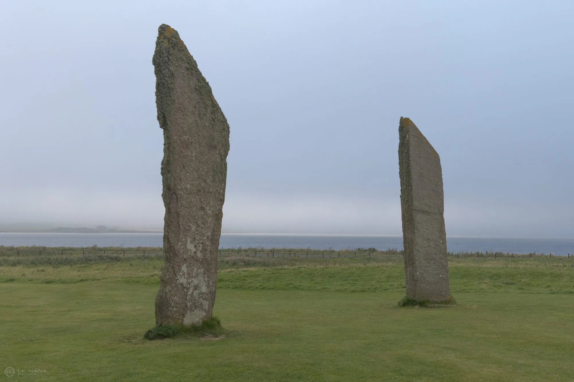 Two standing stones in mist on open grass